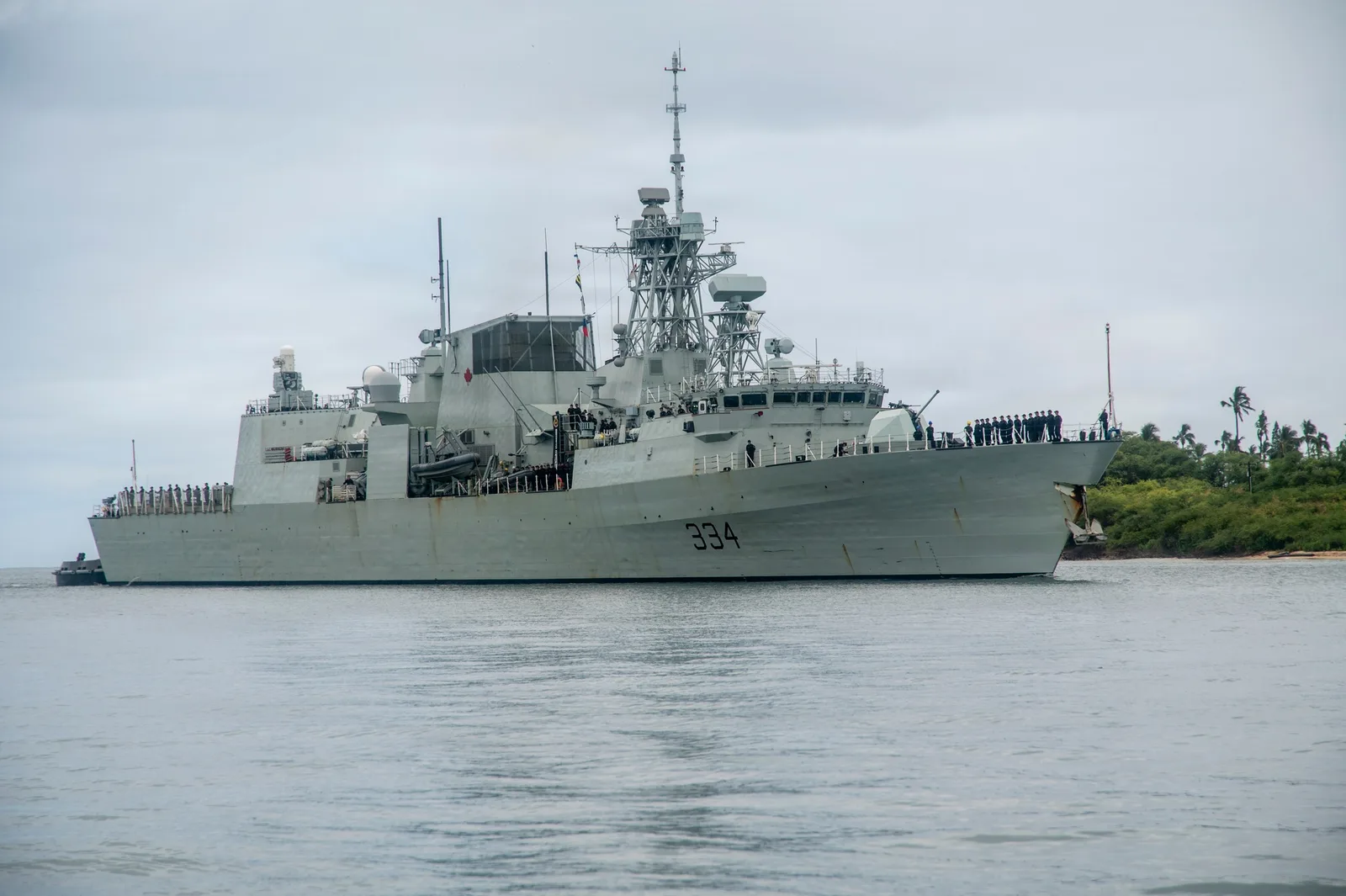 HMCS Regina, hull number 334, enters Pearl Harbor with sailors lining its deck in June 2026.