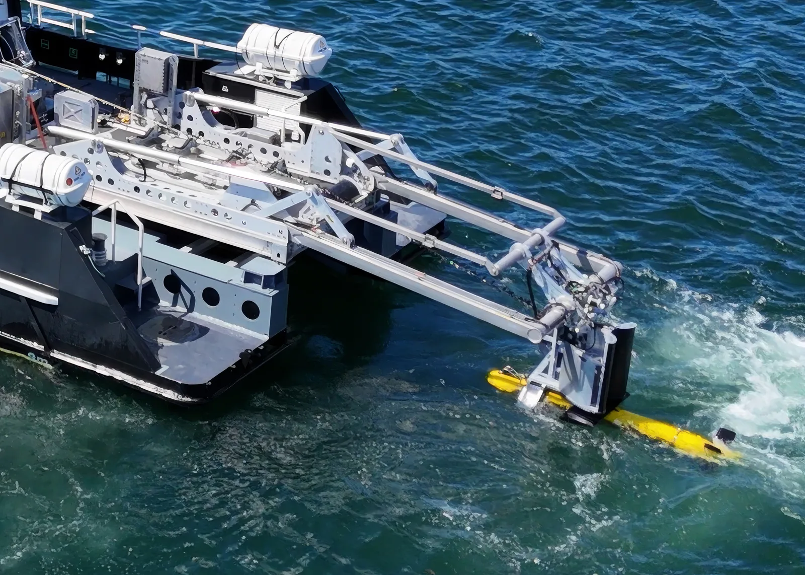 A yellow Kraken Robotics KATFISH sonar towfish being deployed from a vessel.