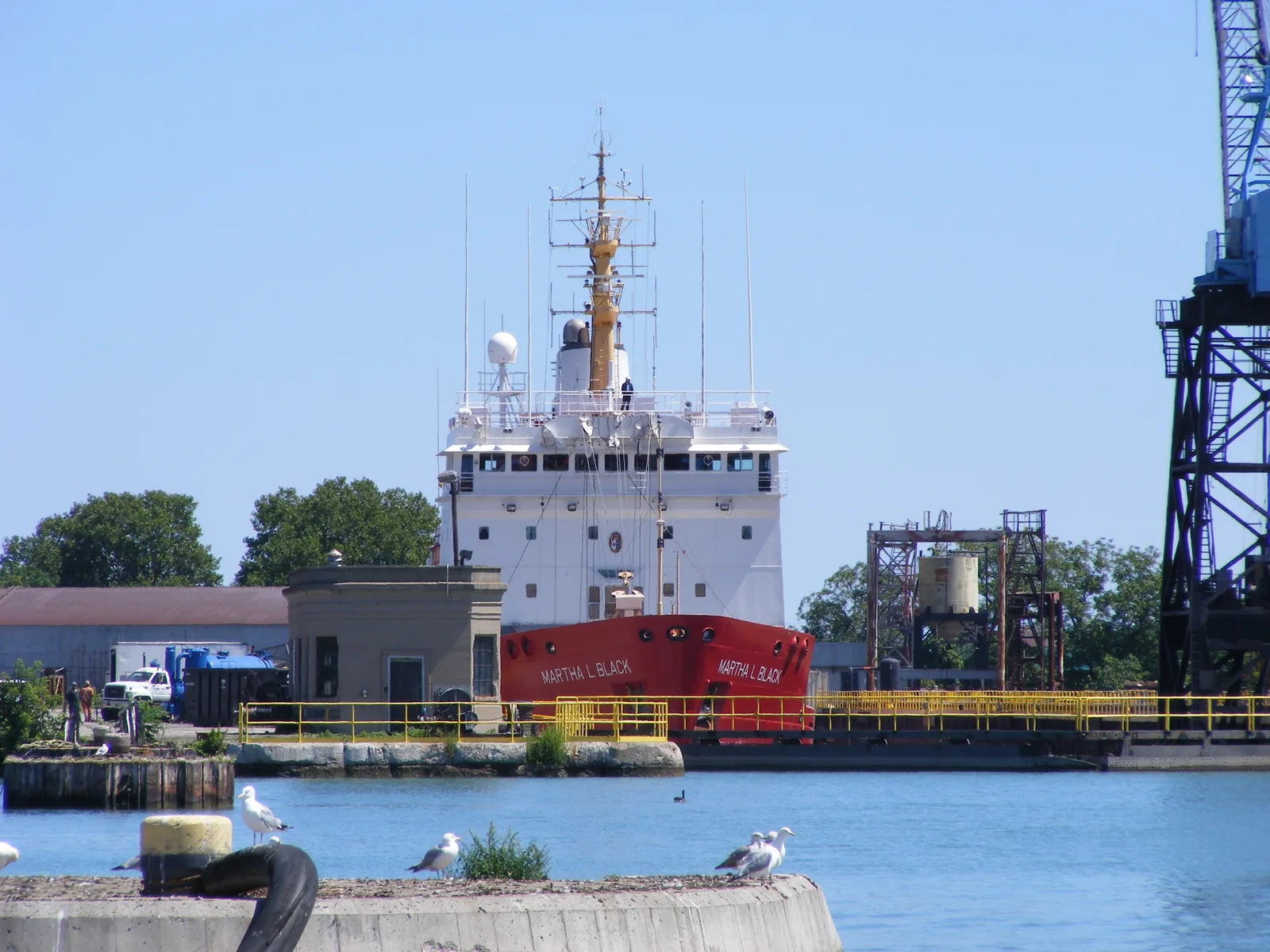 CCGS Martha L. Black sits in Port Weller dry docks beside a crane and shipyard buildings.
