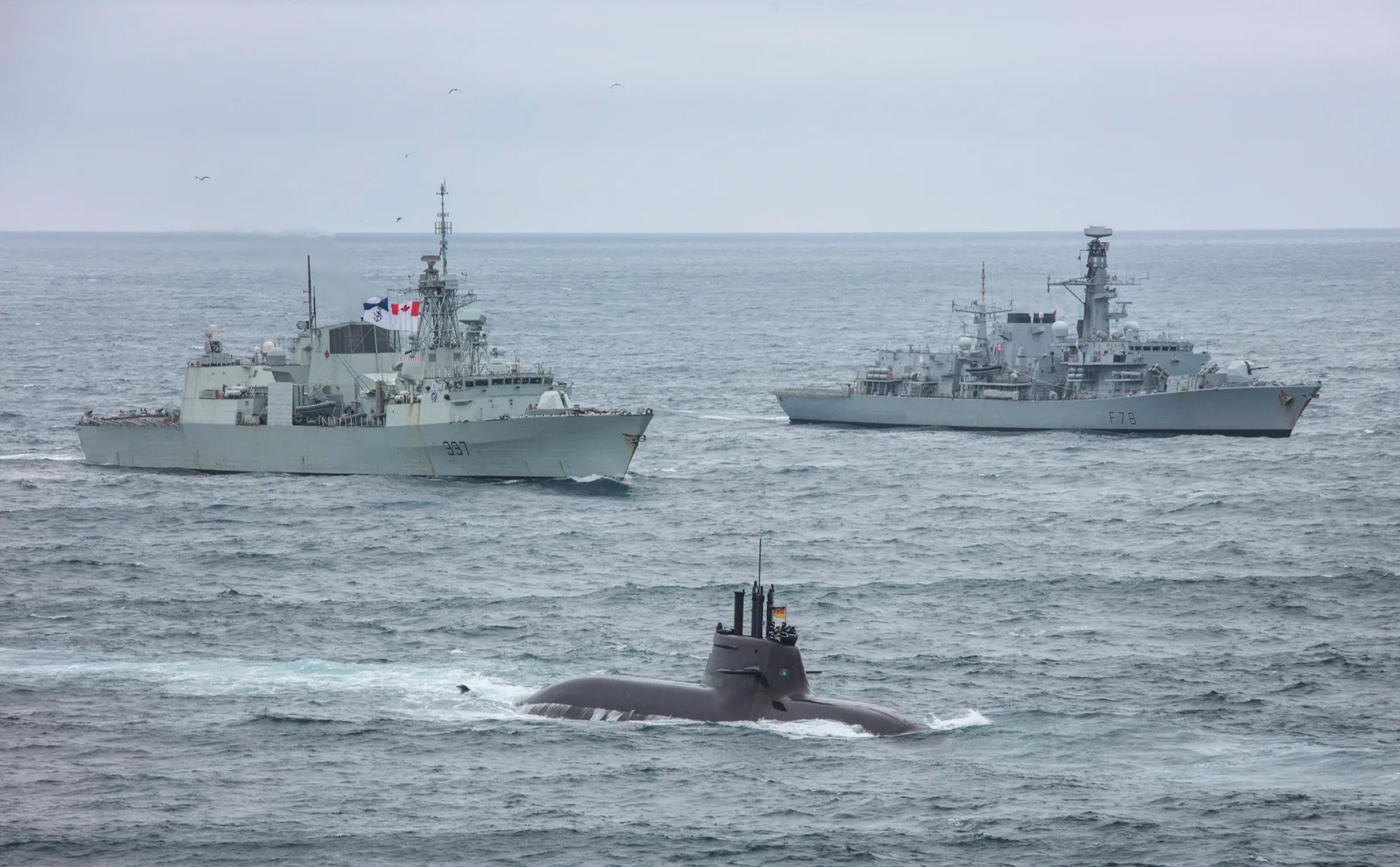 German submarine U-36 sails with HMCS Fredericton and HMS Kent off Iceland.